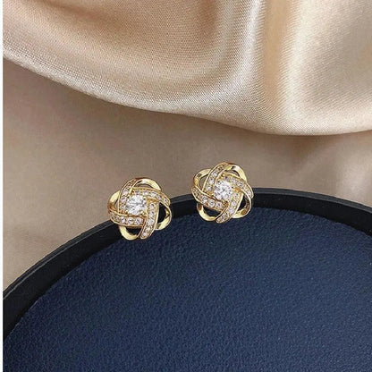 Boucles d'oreilles dorées en spirale florale avec des cristaux